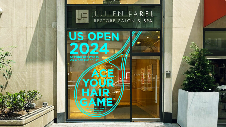Julien Farel Restore Salon & Spa storefront brand campaign with US Open 2024 promotion. Window display reads 'Ace Your Hair Game' in neon blue text with a tennis racket design.
