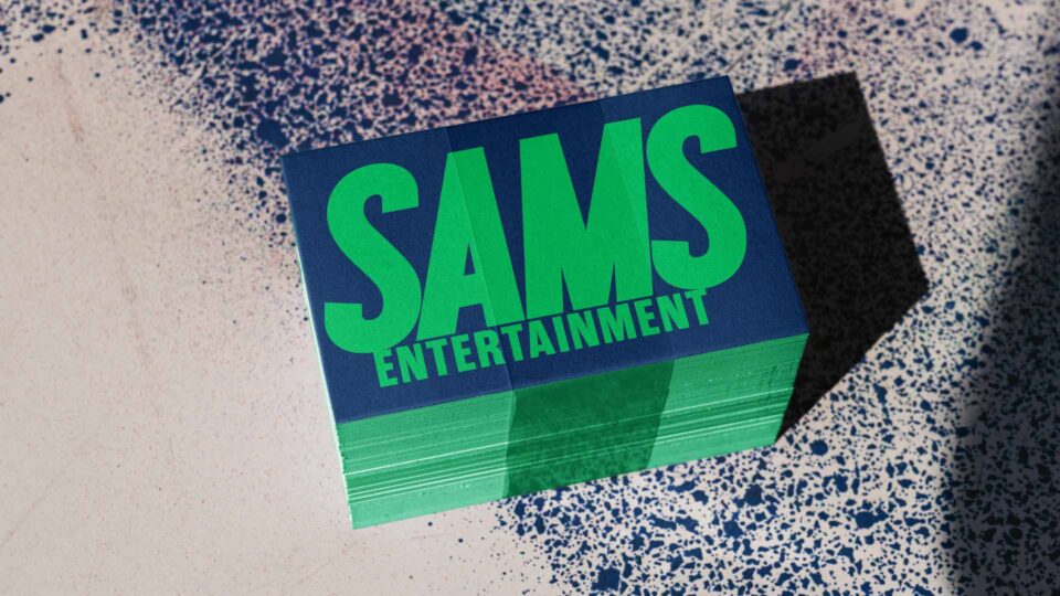 Horizontal SAMS Entertainment business card in navy and green designed by PlanetFab