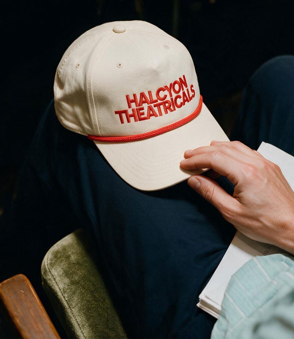Cream cap embroidered with the red Halcyon Theatricals wordmark, shown as a branded apparel application.